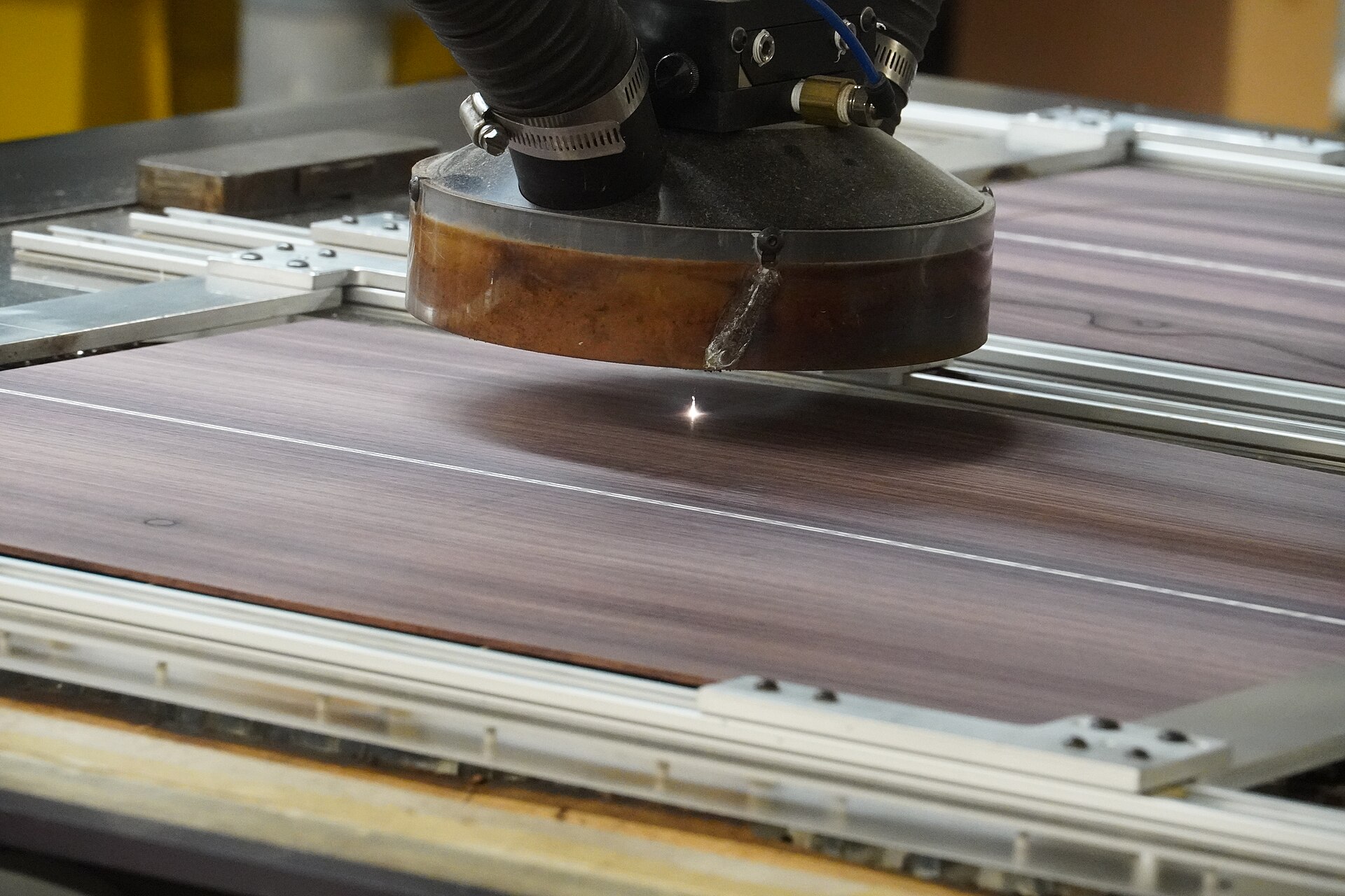 Cabezal de una máquina de corte láser trabajando sobre una plancha